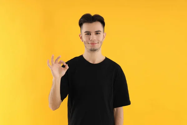 Sarı Arka Planda Tişörtlü Çekici Bir Genç — Stok fotoğraf