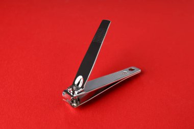 Kırmızı arka planda tırnak makasları, kapat