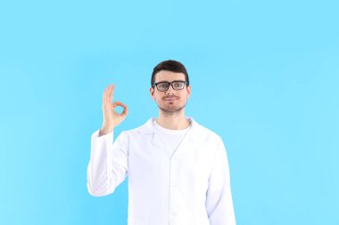 Mavi arka planda genç doktor, sağlık ve tıp