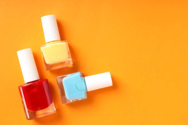 Turuncu arka planda tırnak cilası, kapat.