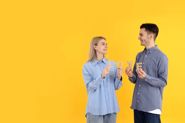 Cute Couple Holds Word Love Yellow Background — 图库照片