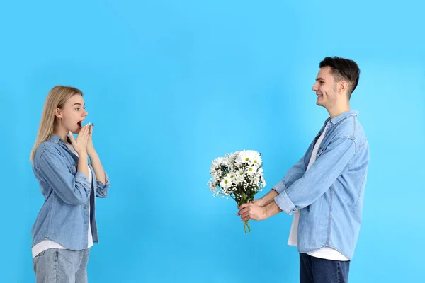 Guy Gives Bouquet Girl Blue Background — Stockfoto