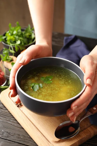 Kadının elinde tavuk çorbası tabağı var.