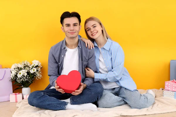 Bonito Feliz Casal Sentado Contra Fundo Amarelo — Fotografia de Stock