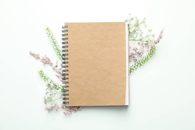 Beyaz arkaplanda çiçekler olan boş bir defter