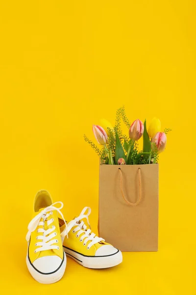 Sneakers Papieren Tas Met Bloemen Gele Achtergrond — Stockfoto