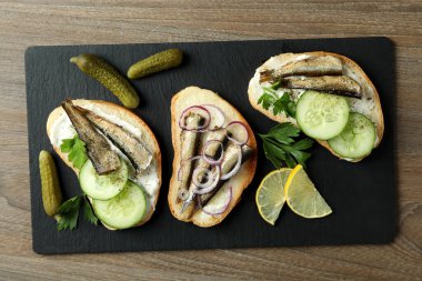 Tahta arka planda lahanalı sandviç tepsisi.