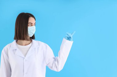 Female doctor in mask and gloves on blue background