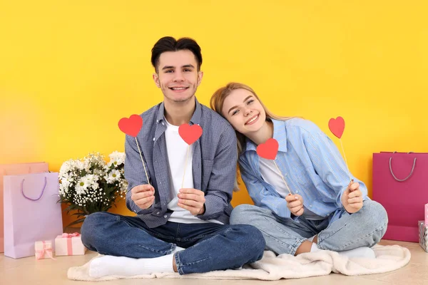 Sarı Arka Planda Oturan Sevimli Mutlu Bir Çift — Stok fotoğraf