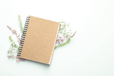 Beyaz arkaplanda çiçekler olan boş bir defter