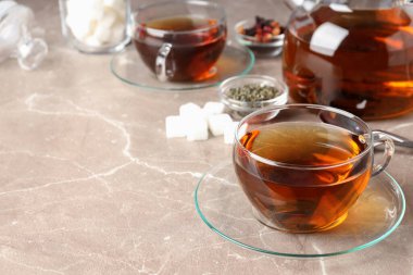 Bej desenli arka planda çay ile sıcak içecek kavramı