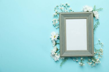 Mavi arkaplanda çiçekli boş fotoğraf çerçevesi
