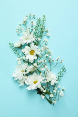 Mavi arka planda çiçekler olan merhaba bahar konsepti