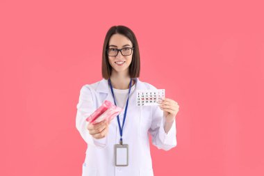 Pembe arka planda pedleri ve periyot takvimi olan stajyer doktor