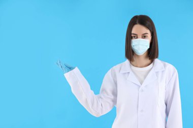 Female trainee doctor on blue background, space for text