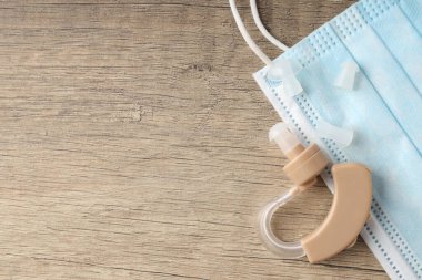 Ahşap arka planda işitme cihazı ile sağlık hizmeti kavramı