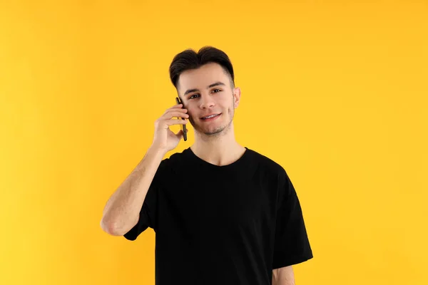 Anak Muda Berbicara Telepon Pada Latar Belakang Kuning — Stok Foto