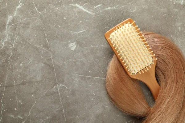 Une Mèche Cheveux Féminins Avec Brosse Cheveux Sur Fond Texturé — Photo