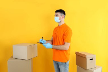 Sarı arka planda panosu olan bir teslimatçı.