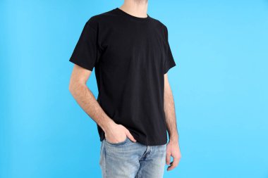 Mavi arka planda siyah tişörtlü adam.