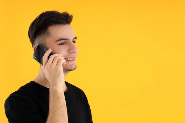 Молодой Человек Говорит Телефону Желтом Фоне — стоковое фото