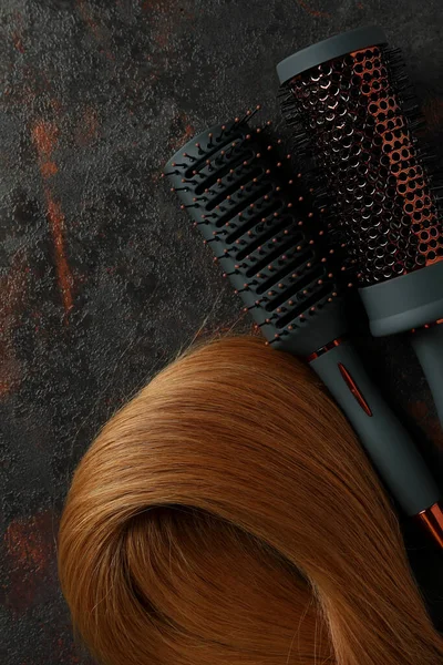 深色背景的带发梳的女性头发 — 图库照片