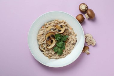 Mantarlı risotto tabağı ve mor arka planda malzemeler