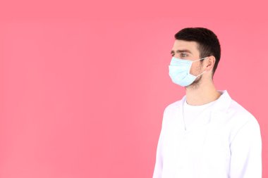 Doktor - pembe arka planda maske takan stajyer