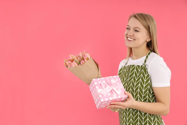 Huisvrouw Met Boeket Geschenkdoos Roze Achtergrond — Stockfoto