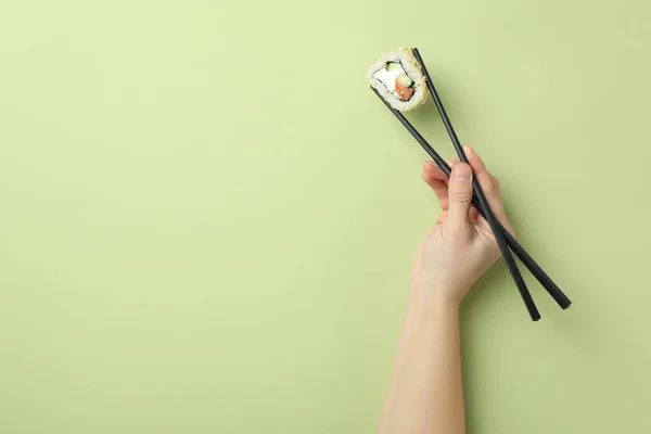 Mano Femminile Tiene Sushi Con Bacchette Sfondo Verde — Foto Stock