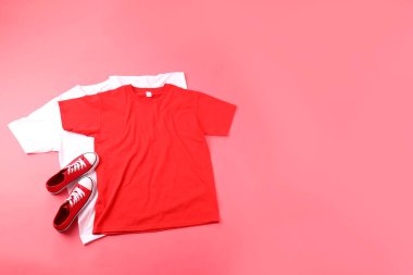 Pembe arka planda boş tişörtler ve spor ayakkabılar