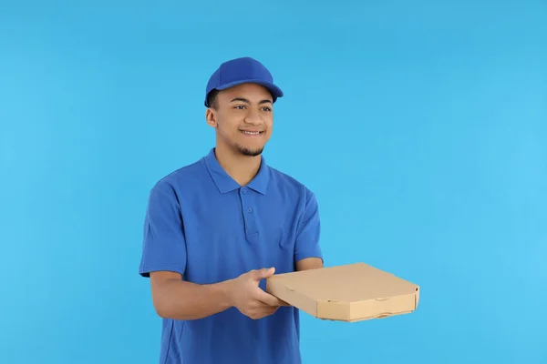 蓝色背景披萨盒的送货员 — 图库照片