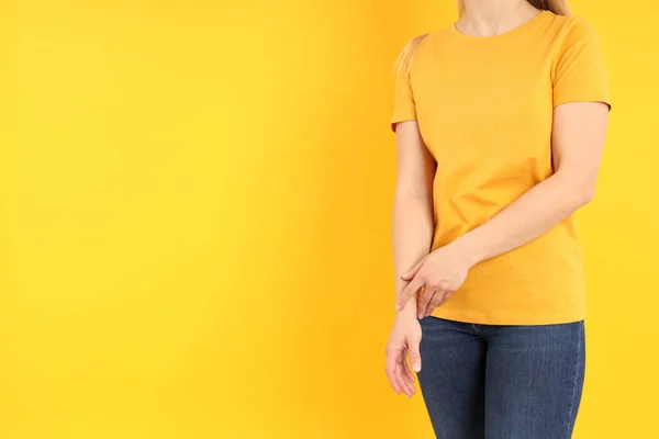 穿着黄色背景的空白橙色T恤的女人 — 图库照片