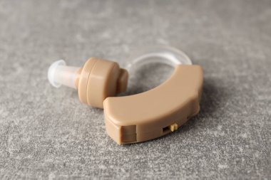 Gri dokulu arka planda işitme cihazı, kapat