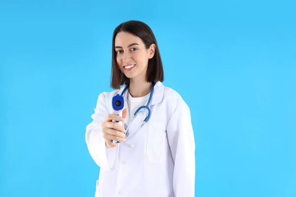 Médica Estagiária Com Arma Termômetro Fundo Azul — Fotografia de Stock