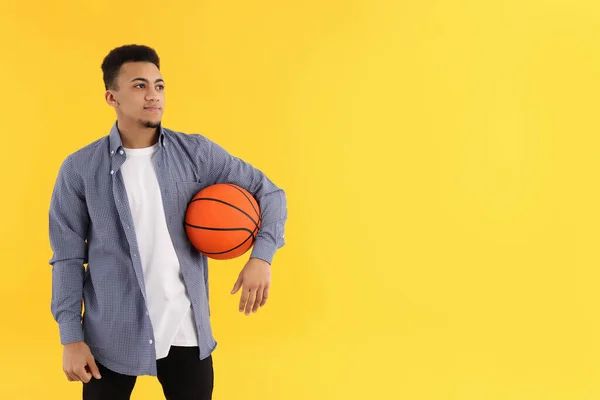 Anak Muda Dengan Bola Basket Latar Belakang Kuning — Stok Foto