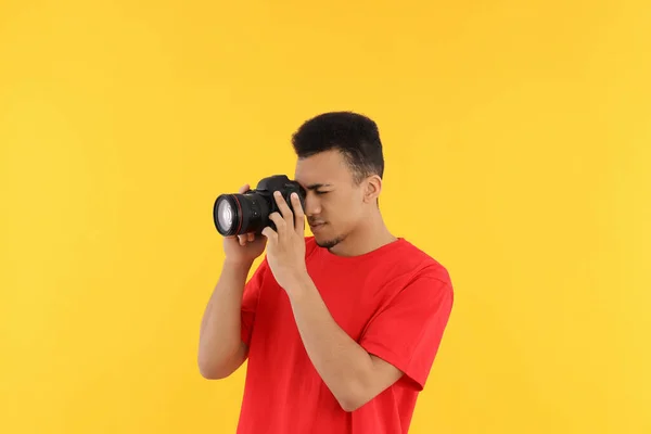 Jongeman Met Een Fotocamera Een Gele Achtergrond — Stockfoto