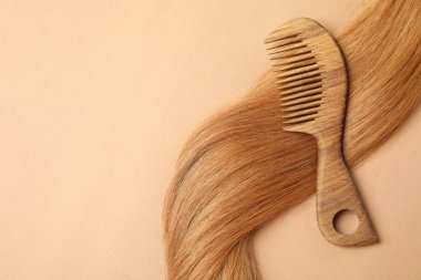 Bej arka planda saç fırçası olan kadın saçı.