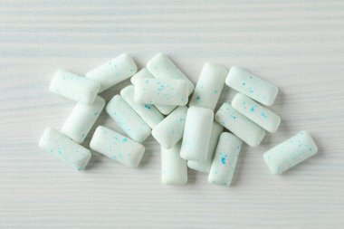 Beyaz ahşap zeminde sakız çiğnemek ya da sakız çiğnemek