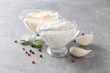 Sarımsak sosu ve gri dokulu arka plandaki malzemeler