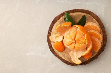 Hafif desenli arka planda yaprakları olan Mandarin tablosu