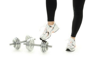 Spor giyimli kadın bacakları ve beyaz arka planda izole edilmiş dambıllar.