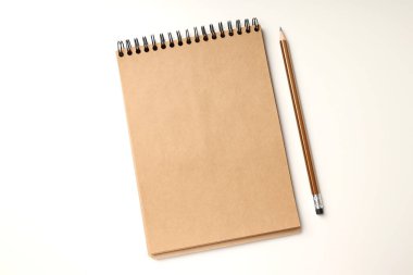 Beyaz arkaplanda kurşun kalem bulunan bir defter