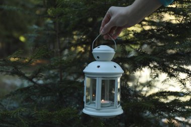 Dişi el ormanda mumla feneri tutuyor.