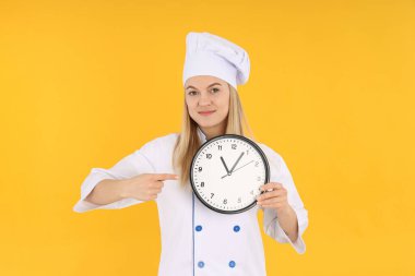 Sarı arka planda genç bir kadınla yemek pişirme kavramı