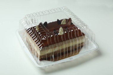 Beyaz arka planda plastik kapta tiramisu keki