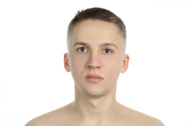 Temiz yüzlü genç adam beyaz arka planda izole edilmiş.