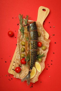 Kırmızı arka planda füme uskumru ile lezzetli yemek kavramı