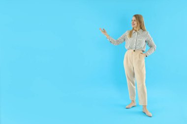 Mavi arka planda genç ve çekici bir iş kadınıyla iş yapma kavramı