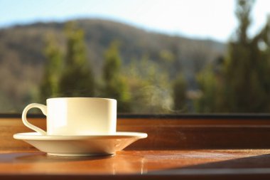 Bir fincan çay ahşap pencere eşiğinde duruyor.